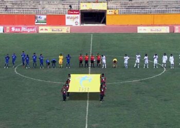 Partido de fútbol disputado en un estadio con jugadores en la cancha