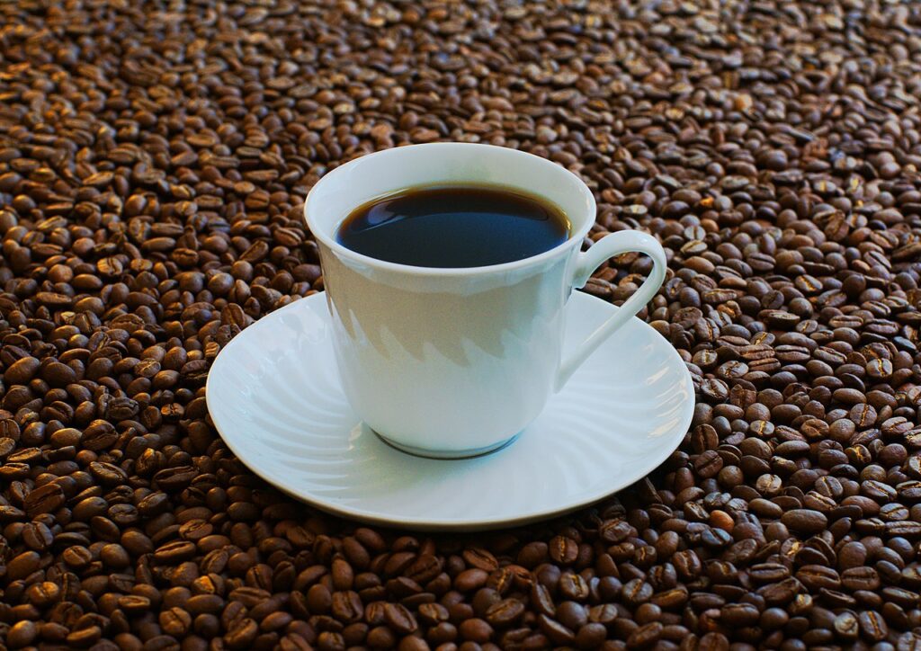 Una taza de café rodeada de granos de café tostado