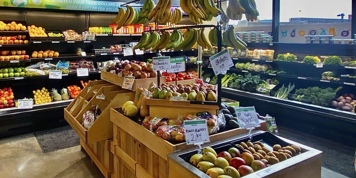 Frutas y verduras a la venta en un mercado, ilustrando el alza de precios de los alimentos