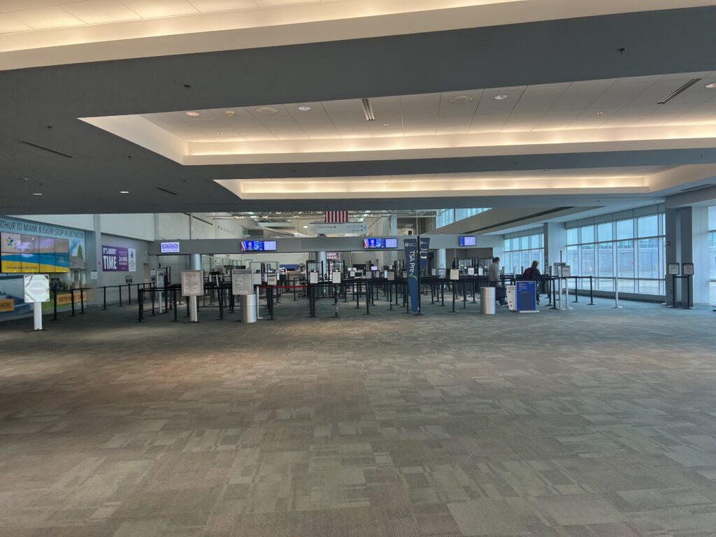 Interior de la terminal de un aeropuerto con pasajeros