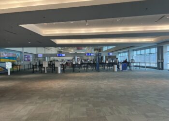 Interior de la terminal de un aeropuerto con pasajeros