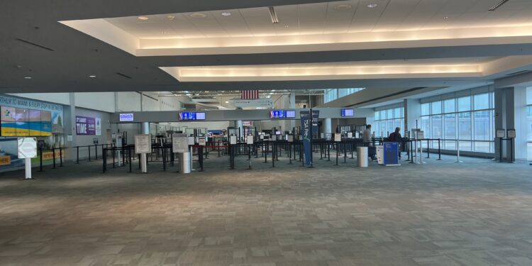 Interior de la terminal de un aeropuerto con pasajeros