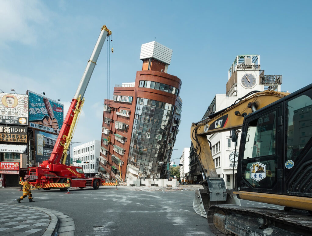 Rescatistas junto a un edificio parcialmente derrumbado tras un terremoto