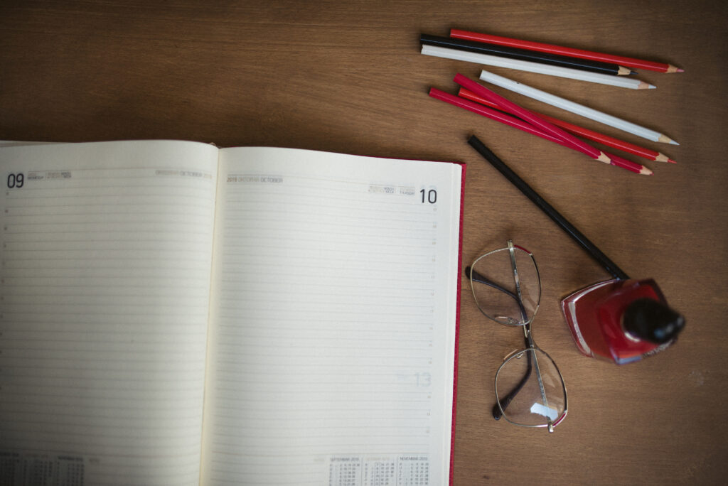 Cuadernos, lápices de colores y otros útiles escolares sobre un escritorio de madera
