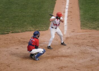 Un bateador de beisbol se prepara para golpear la pelota junto al receptor