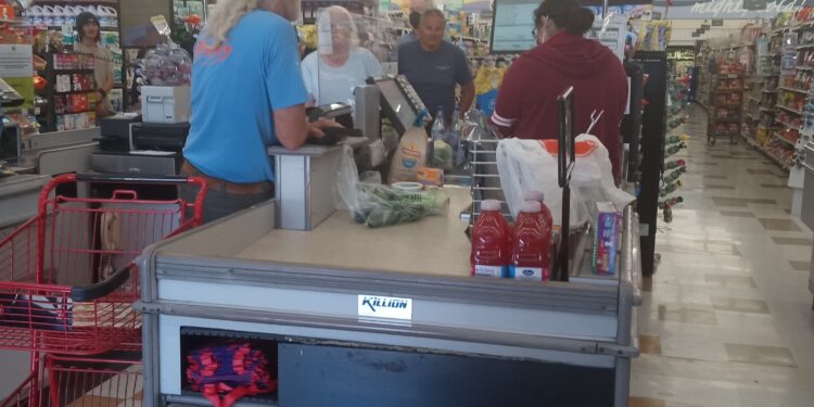 Consumidores en la fila de pago de un supermercado