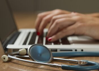 Estetoscopio junto a una computadora portátil, imagen sobre atención médica y seguros de salud