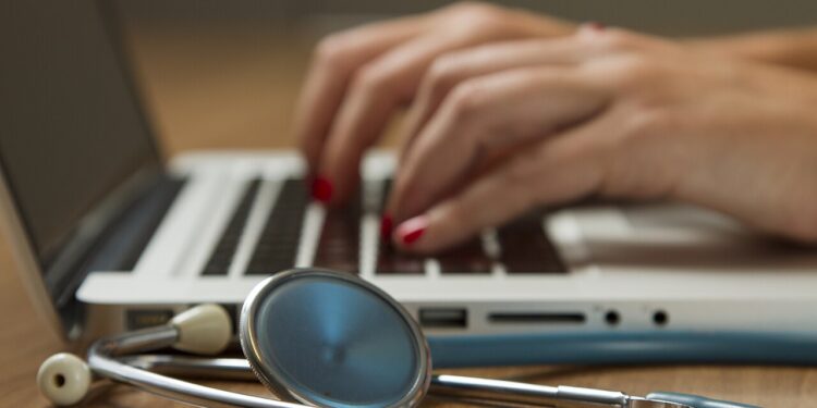Estetoscopio junto a una computadora portátil, imagen sobre atención médica y seguros de salud