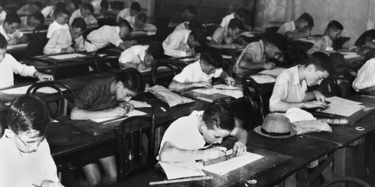 Estudiantes realizan un examen dentro de un salón de clases