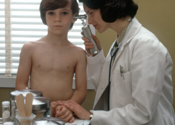 Una médica examina a un niño pequeño durante una consulta