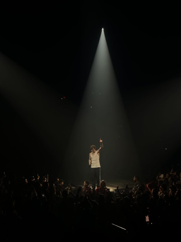 El cantante Peso Pluma actuando en concierto durante su gira