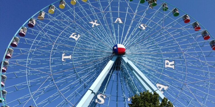 Rueda de la fortuna iluminada en una feria estatal por la noche