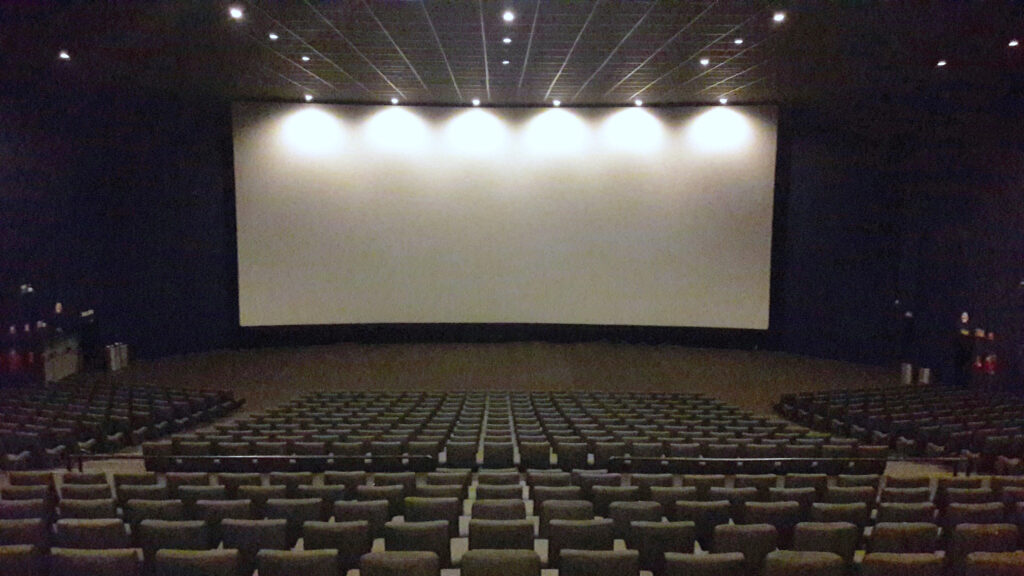 Interior de una sala de cine con butacas y pantalla