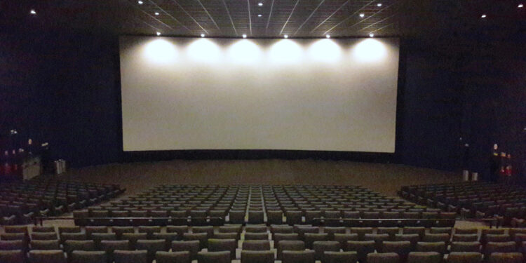 Interior de una sala de cine con butacas y pantalla