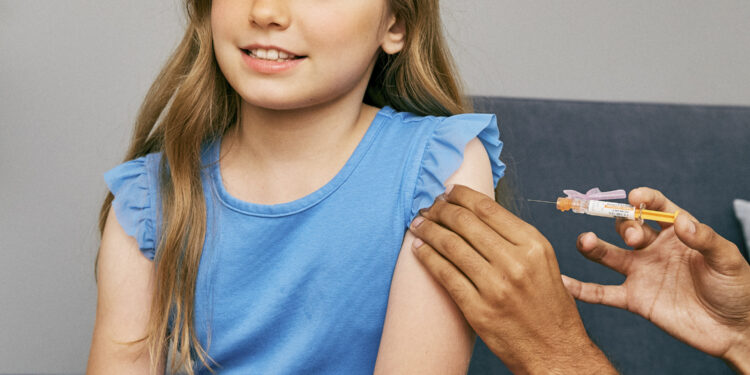Una niña a punto de recibir una vacuna en el brazo