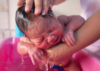 Un bebé durante la hora del baño, relacionado con un retiro de asientos de baño para bebés