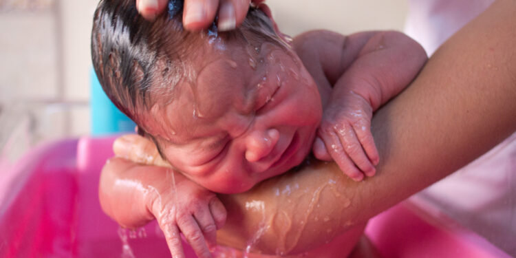 Un bebé durante la hora del baño, relacionado con un retiro de asientos de baño para bebés